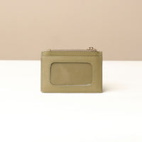back view of a nappa leather card case nirua in olive green brown with gold accents over a beige background