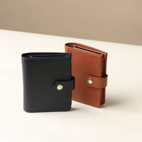 Two RFID blocking card cases with snap closures, one in black and one in brown, displayed side by side on a light background.