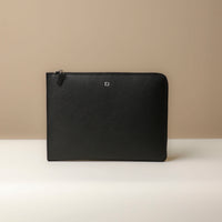 A black leather document folder resting on a laptop, highlighting its use for storing documents.