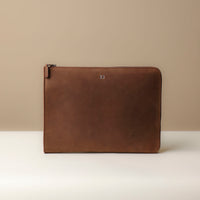 A brown leather document folder resting on a laptop, highlighting its use for storing documents.