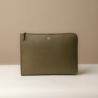 A olive leather document folder resting on a laptop, highlighting its use for storing documents.
