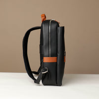 Black backpack with brown accents on a beige background