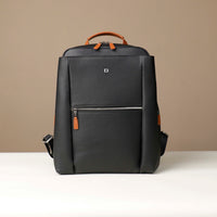 Black backpack with brown accents on a beige background