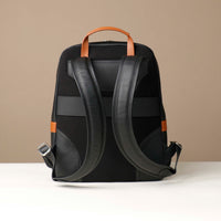 Black backpack with brown accents on a beige background