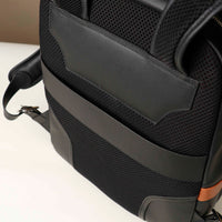 Close-up of a black backpack with a brown accent on a white background