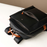 Black backpack with brown accents on a white surface