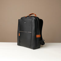Black backpack with brown accents on a beige background