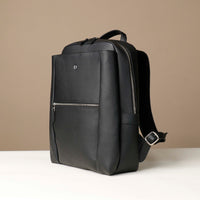 Black backpack with a visible brand logo on a beige background