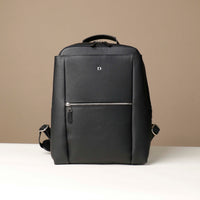 Black backpack with a visible brand logo on a beige background