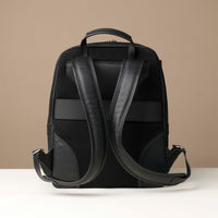Black backpack with leather straps on a beige background