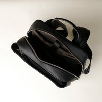 Black leather bag on a light gray background