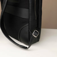 Black backpack with a strap and buckle on a white surface