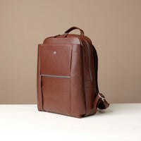 Brown leather backpack on a beige background