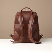 Brown leather backpack on a beige background