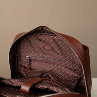 Brown patterned backpack with visible brand logo on a beige background
