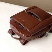 Brown leather backpack on a white surface