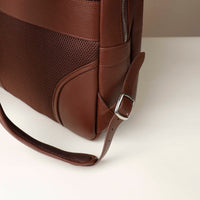Brown leather bag with a strap on a white background