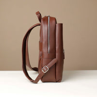 Brown leather backpack on a beige background