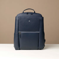 Navy blue backpack with a visible brand logo on a beige background
