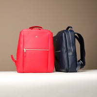 Red and blue backpacks on a beige background