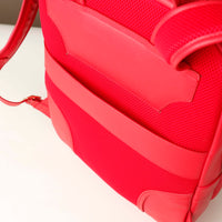 Close-up of a red textured bag with a strap on a light background