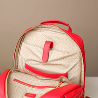 Red backpack with beige interior on a neutral background