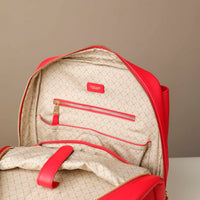 Red and beige backpack with a visible brand logo on a neutral background