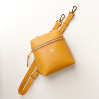 Yellow leather crossbody bag on a white background