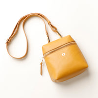 Yellow handbag with a strap on a white background