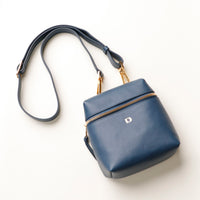 Blue handbag with gold zipper on a white background