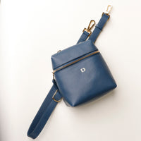 Blue leather bag with a strap on a white background