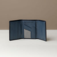 A open trifold wallet in black and lavanda color, made from pebbled leather with nappa leather interior, with 6 slots for cards and a long comparment for cash, displayed against a neutral background.