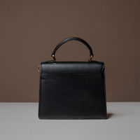 Back View of Black Nelda Bag elegant leather handbag with detachable shoulder strap on a neutral background