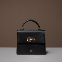 Front View of Black Nelda Bag elegant leather handbag with detachable shoulder strap on a brown background