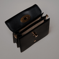 Top View of Black Nelda Bag elegant leather handbag with detachable shoulder strap on a gray background