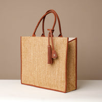 Angled View of Raffia Mercatto tote bag, a lightweight, artisanal woven bag crafted from natural raffia.
