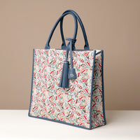 Angled View of Raffia Mercatto tote bag, a lightweight, artisanal woven bag crafted from natural raffia.