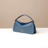 Side view of blue Penelope Mini small leather handbag for versatile everyday use