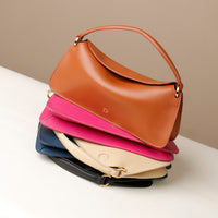 A stack of Penelope Mini small leather handbag for versatile everyday use