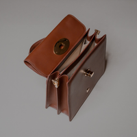 Top View of Brown Nelda Bag elegant leather handbag with detachable shoulder strap on a gray background