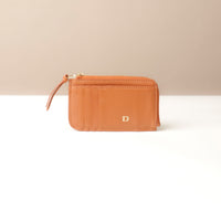 Brown wallet with a visible brand logo on a beige background