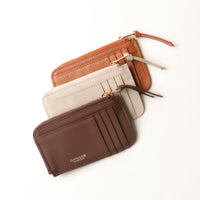 Three leather wallets in brown and beige on a white background