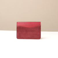 Red suede leather Danilos cardholder on a beige background
