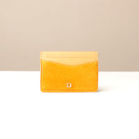Yellow suede leather cardholder with a Danilos logo on a beige background