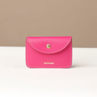 Pink wallet with 'DANILOS' branding on a beige background