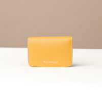 Yellow wallet with 'Made in Honduras' text on a beige background