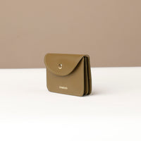 Green wallet with 'DANILLOS' branding on a beige background