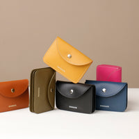 Set of colorful leather wallets with 'DANILOS' branding on a beige background