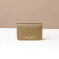 Beige leather wallet with 'Made in Honduras' text on a beige background