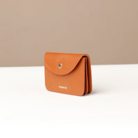 Brown wallet with 'DANILLOS' branding on a beige background
